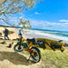 Beast Ebike Parked Near a Beach with a Surfboard Attached to its Side